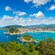 Montañas verdes alrededor de una bahía llena de botes y rodeada de arquitectura de fines del siglo XIX